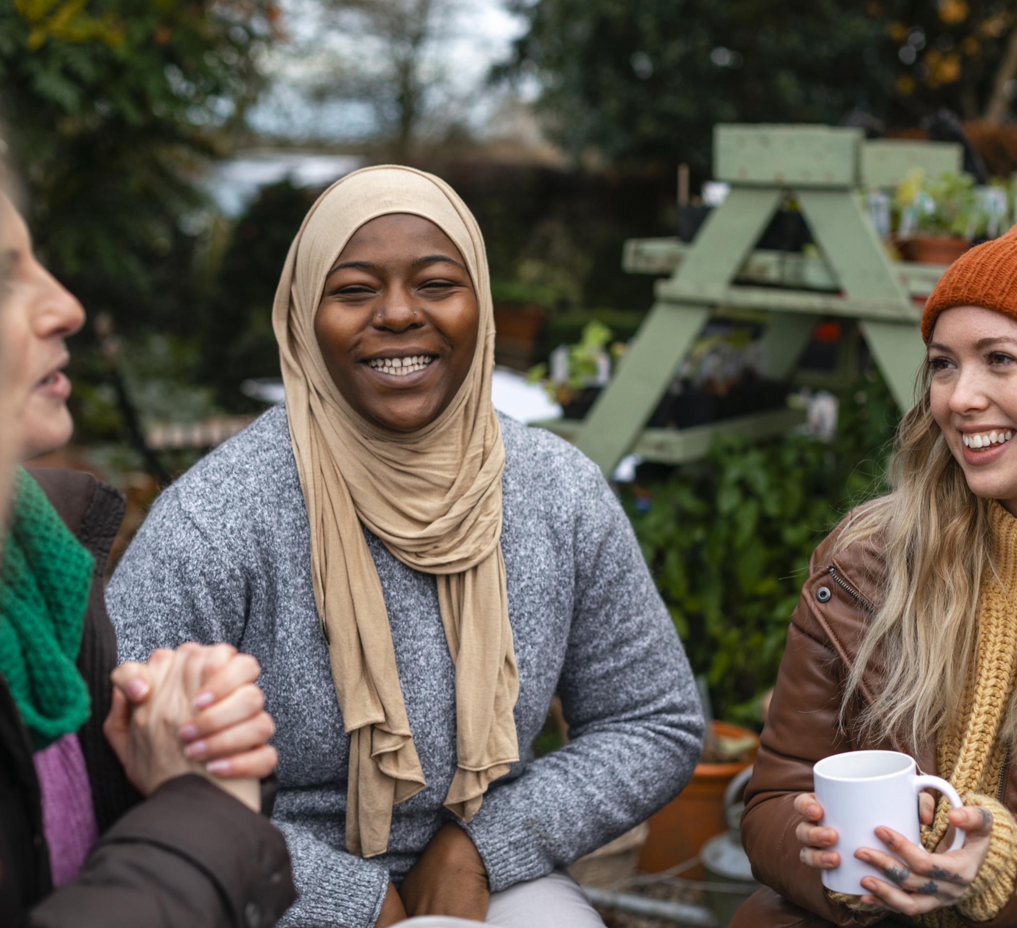 group of 3 people having a cup of tea and talking to eachother