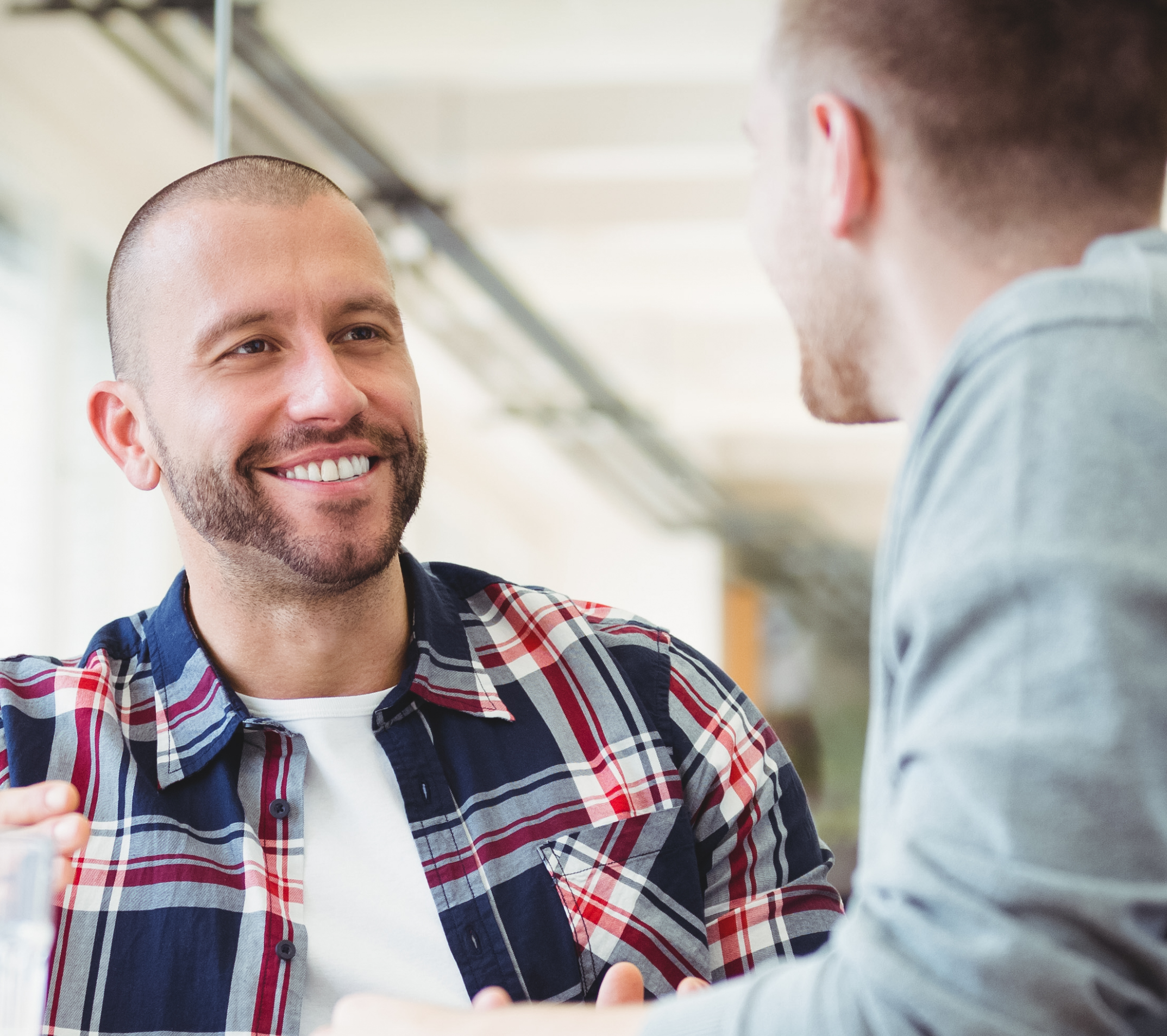 two man having a conversation smiling at eachother